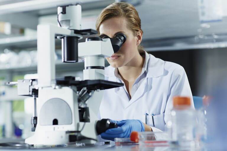 kobieta doktor badająca próbkę pod mikroskopem